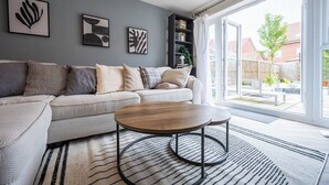 Ein modernes Wohnzimmer mit einer Couch, einem Couchtisch und einem Kunstwerk an der Wand.