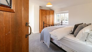 A bedroom with a bed, a wooden wardrobe, a window, and a hanging light fixture. - 35 Main Street (Nottingham)