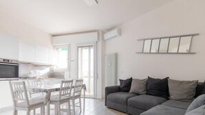 A modern apartment with a kitchen, dining area, and living room.