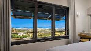 Quarto de hotel com uma grande janela que oferece vista da paisagem.