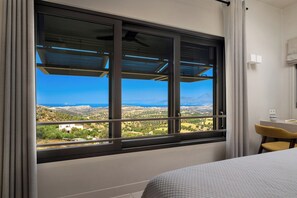 A hotel room with a large window offering a view of the landscape.