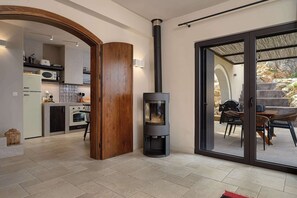 A modern kitchen with a built-in stove, a dining area with outdoor seating, and a large sliding glass door leading to an outdoor patio.