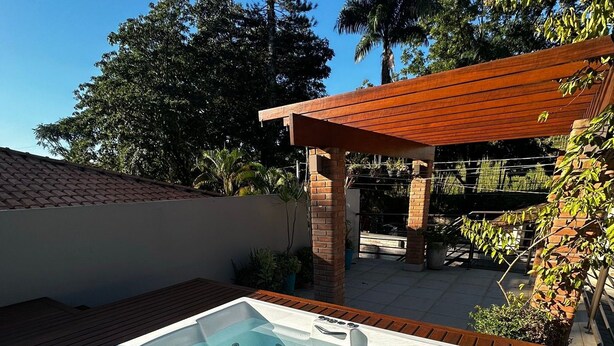 A hot tub on a wooden deck with a pergola overhead. - Recanto das Videiras (Itapira)