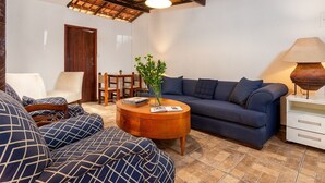 A cozy living room with a sofa, armchair, and a coffee table. - Pousada Via Mar Buzios (Búzios)