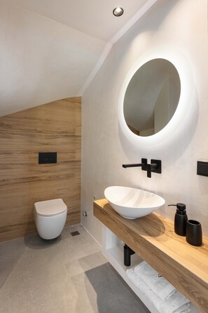 Luxe villa | Badkamer | Een douche, een haardroger, handdoeken, zeep