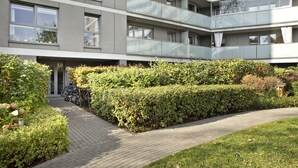 Ein modernes, mehrstöckiges Gebäude mit gepflastertem Weg und ordentlich gestutzten Hecken.