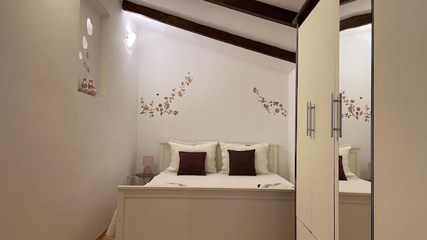 A bedroom with a bed, a nightstand, and a wardrobe. - Apartment Ivan (Rovinj)