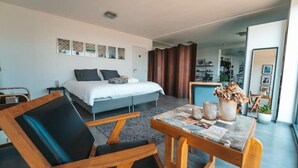 Une chambre d’hôtel moderne équipée d’un lit, d’une table à manger et d’un coin salon.