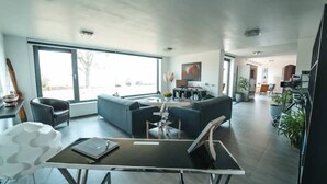 Un salon moderne avec un canapé, une table à manger et une grande fenêtre.