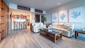A spacious living area with a sofa, coffee table, and a kitchen in the background. - Oceanfront Residence with Beach Access (Huatulco)