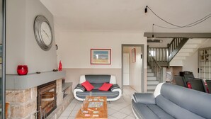 Una sala de estar con chimenea, un sofá, una mesa de centro y una escalera.