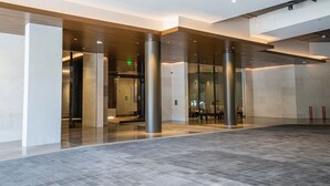 A spacious lobby with a modern design, featuring a large open area, glass doors leading to a reception area, and a polished floor. - Newly Built, Hottest Condo at "Sky Ala Moana" 10th Floor  1 Bedroom (SAW1005) (Honolulu)