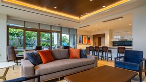 A modern living room with a sofa, chairs, a coffee table, and a kitchen area in the background. - Newly Built, Hottest Condo at "Sky Ala Moana" 10th Floor  1 Bedroom (SAW1005) (Honolulu)