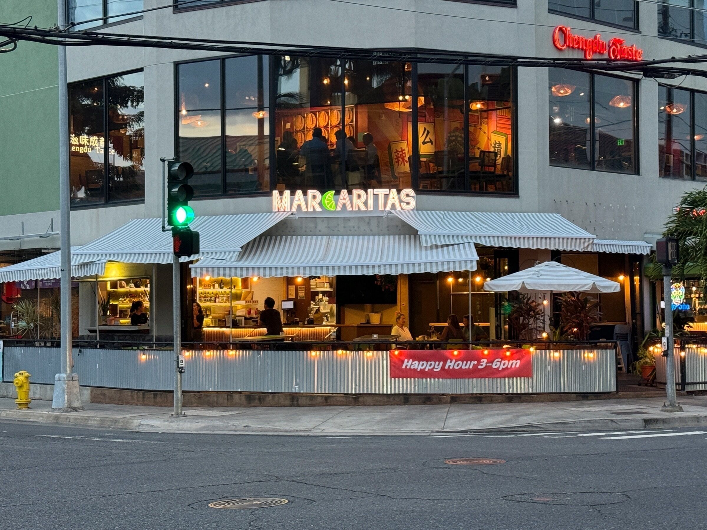 En restaurang som heter ”Margaritas” med uteservering och en skylt som visar att de har ”Happy Hour mellan 15.00 och 18.00”.