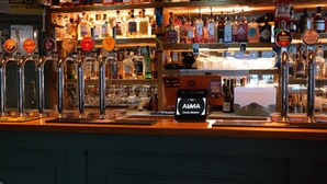 Un bar doté de plusieurs robinets à bière et d’un écran numérique affichant le texte « CHAPEL MARKET ».