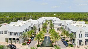 Un hotel con un cortile centrale, palme e un elemento d'acqua.