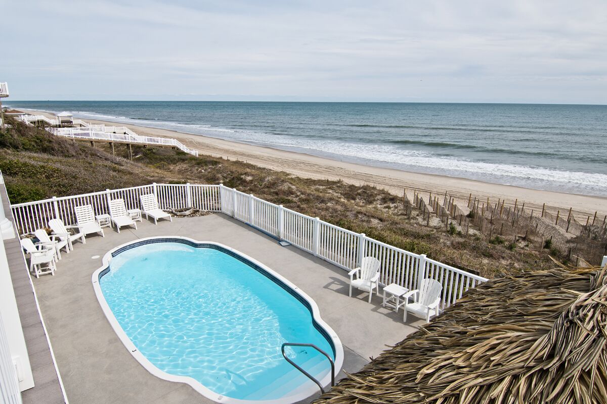 A swimming pool with a view of the beach and ocean.