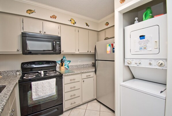 A kitchen with a stove, microwave, and refrigerator.