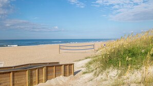 A beach with a wooden boardwalk leading to a sign that reads "A Place at the Beach." - A Place At The Beach 369, Oceanside Condo in Atlantic Beach, NC! (Atlantic Beach)