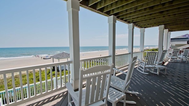A wooden deck with white chairs overlooking a beach. - A Sandy Ridge, Oceanfront House in Emerald Isle, NC! (Emerald Isle)