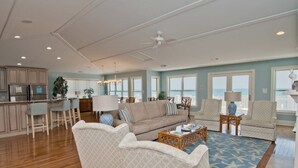 A spacious living area with a kitchen, a dining area, and a view of the ocean. - A Sandy Ridge, Oceanfront House in Emerald Isle, NC! (Emerald Isle)