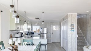 A modern kitchen with a central island, stainless steel appliances, and pendant lighting. - A Wave From it All, Oceanfront Duplex in Emerald Isle, NC! (Emerald Isle)
