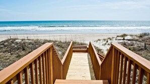 A wooden boardwalk leading to a beach with a clear view of the ocean. - Agape West, Oceanfront Duplex in Emerald Isle, NC! (Emerald Isle)