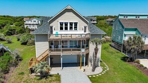 A two-story house with a balcony, a covered porch, and a driveway leading to the garage.