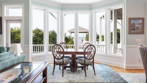 Un coin repas avec une baie vitrée, une table, des chaises et une vue sur l’extérieur.