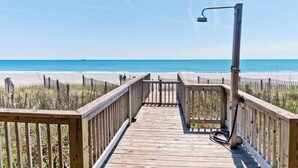A wooden boardwalk leading to a beach with a clear view of the ocean. - At Anchor East, Oceanfront Duplex in Emerald Isle, NC! (Emerald Isle)