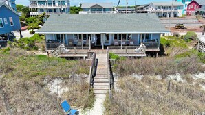 A beachfront house with a wooden deck and a covered porch. - At Anchor East, Oceanfront Duplex in Emerald Isle, NC! (Emerald Isle)