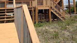 A multi-story wooden building with balconies and a staircase leading to the upper levels. - Atlantic Sea Oats, Oceanfront Duplex in Emerald Isle, NC! (Emerald Isle)