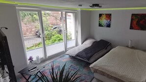 A bedroom with a bed, a window, and a door.