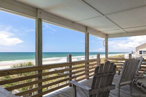 A wooden deck with chairs overlooking a beach. - Aurora West, Oceanfront Duplex in Emerald Isle, NC! (Emerald Isle)
