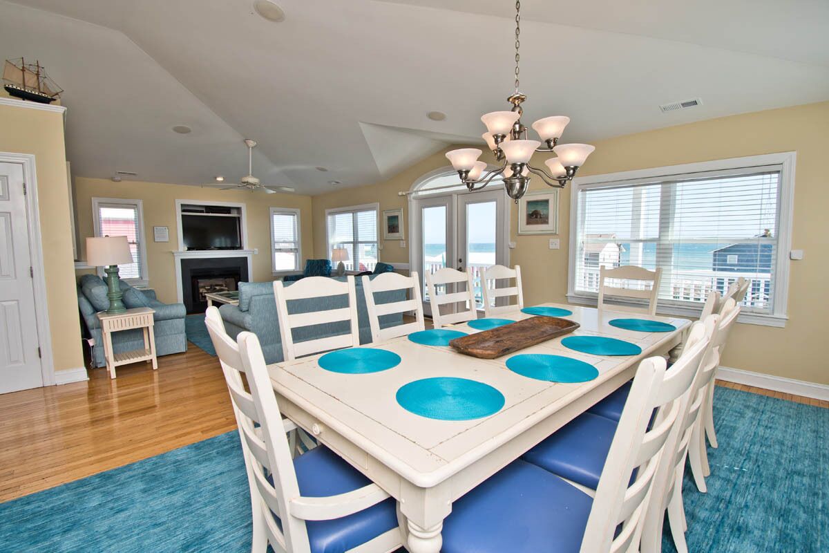 A dining area with a table, chairs, and a chandelier.