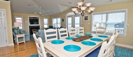 A dining area with a table, chairs, and a chandelier.