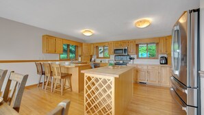 Una cocina moderna con armarios de madera, electrodomésticos de acero inoxidable y una isla central.