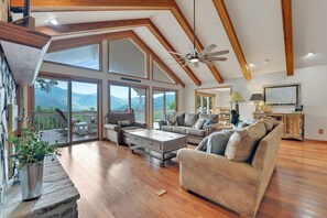 A spacious living room with a high ceiling, large windows, and a view of mountains. - Million Dollar Views, PRIVATE, Golf, Hot Tub, Game Room, Hike (Maggie Valley)
