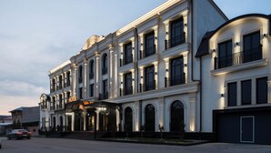 Ett hotell med flera våningar, byggt i en klassisk arkitektonisk stil, med välvda fönster och balkonger.