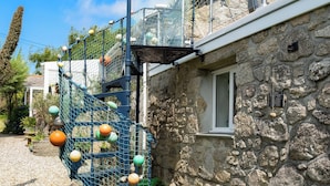 A stone building with a blue climbing structure and a window.