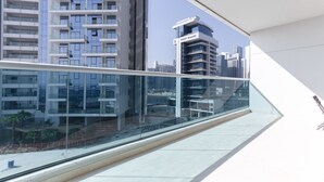 Ein modernes Gebäude mit einem Glasbalkon und Blick auf die Stadtlandschaft.
