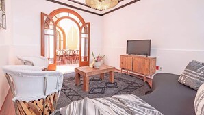 Un salon chaleureux avec un téléviseur, des meubles en bois et un tapis à motifs.