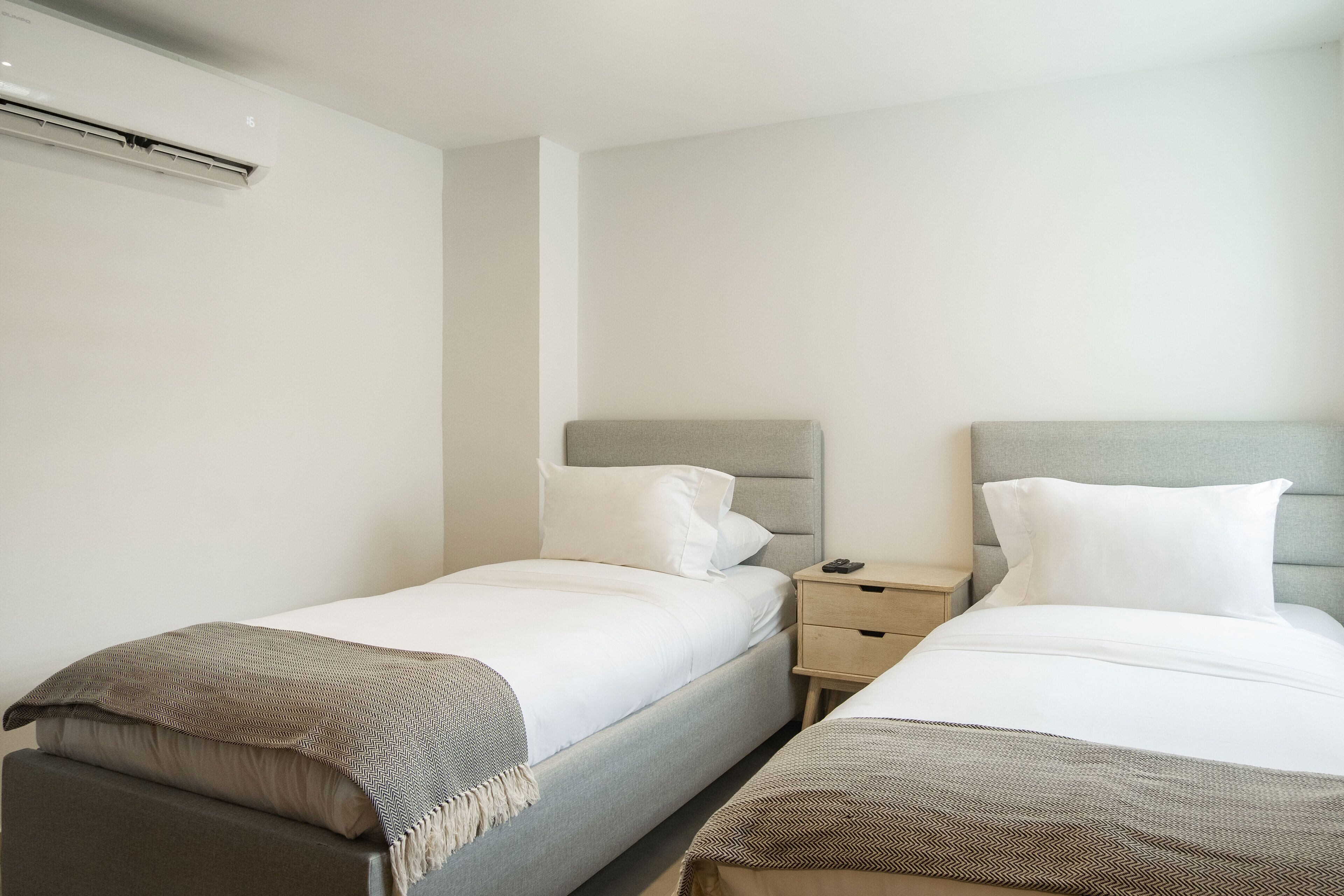 A twin room with two single beds, each with a bedside table and a lamp.
