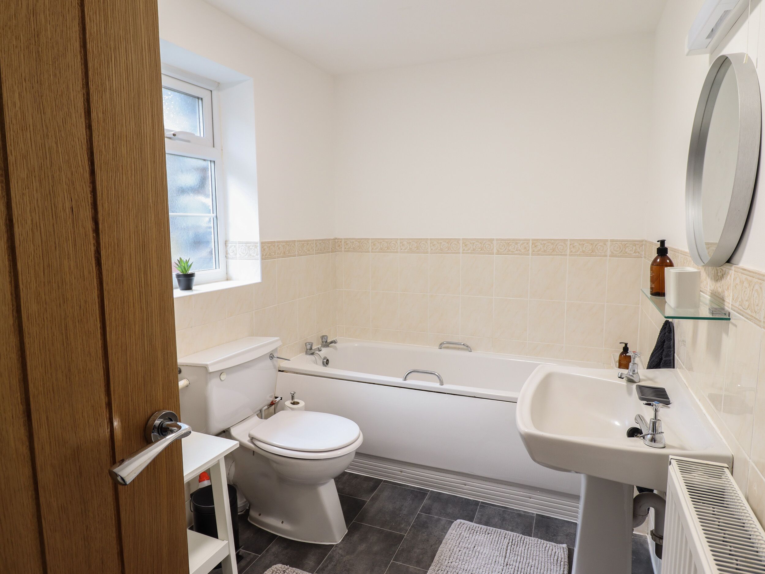 A modern bathroom with a toilet, bathtub, and sink.