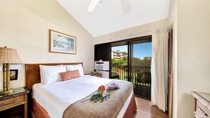 Ein Hotelzimmer mit Bett, Nachttisch, Lampe, einem Gemälde und einem Balkon mit Blick.