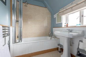 A bathroom with a bathtub, a sink, and a shower. - Stables Loft | Elie (Elie)