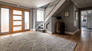 A spacious foyer with a wooden staircase, a large rug, and a barrel. - Rosemount | Kilrenny (Kilrenny)
