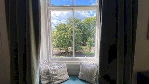 Ein Fenster mit Blick auf Bäume und einen Zaun.