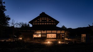 Ein traditionelles japanisches Haus mit Ziegeldach, Holzbauweise und einem Innenhof.