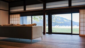 Ein Zimmer mit einer Couch, großen Fenstern und Bergblick.